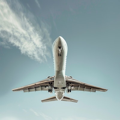 Airplane Taking Off into Clear Sky - A close-up view from below of an airplane taking off against a clear blue sky. The powerful image captures the aircraft's ascent and the intricate details of its underside.