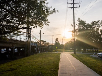 Sun Above Sidewalk and Train Station