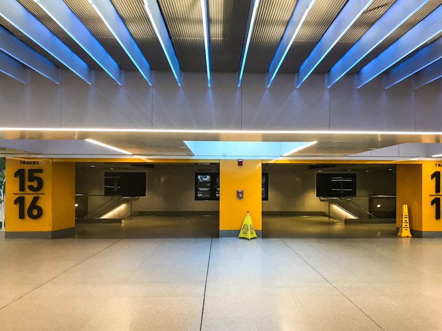 Photo: A yellow and orange train station with blue lighting 