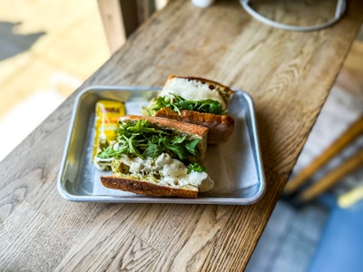 Sandwich at Cafe - A sandwich with greens on a tray