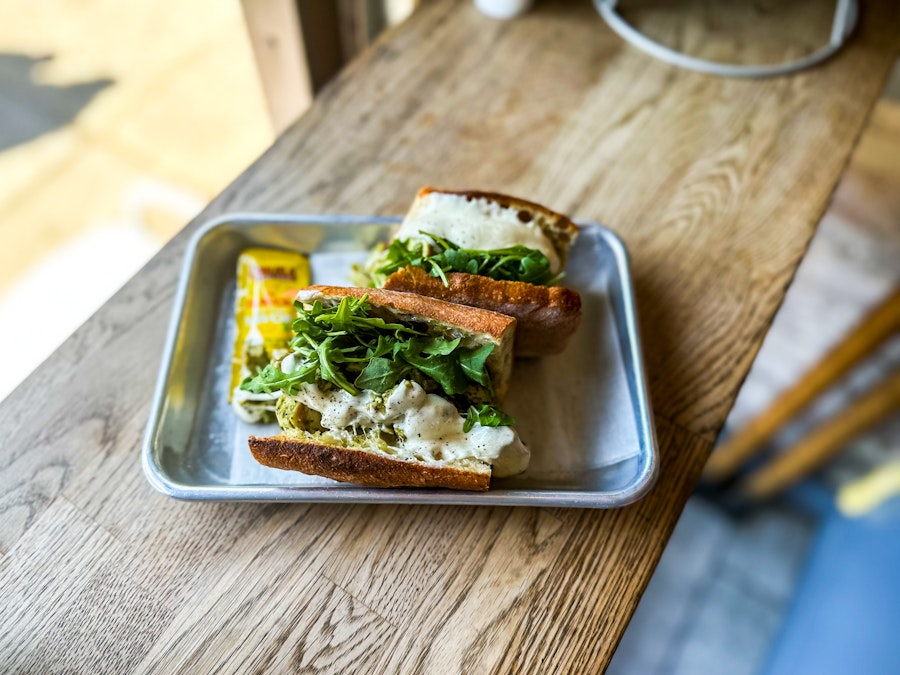 Photo: A sandwich with greens on a tray