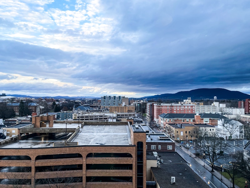 Photo: Aerial view of a city with buildings and mountains in the background