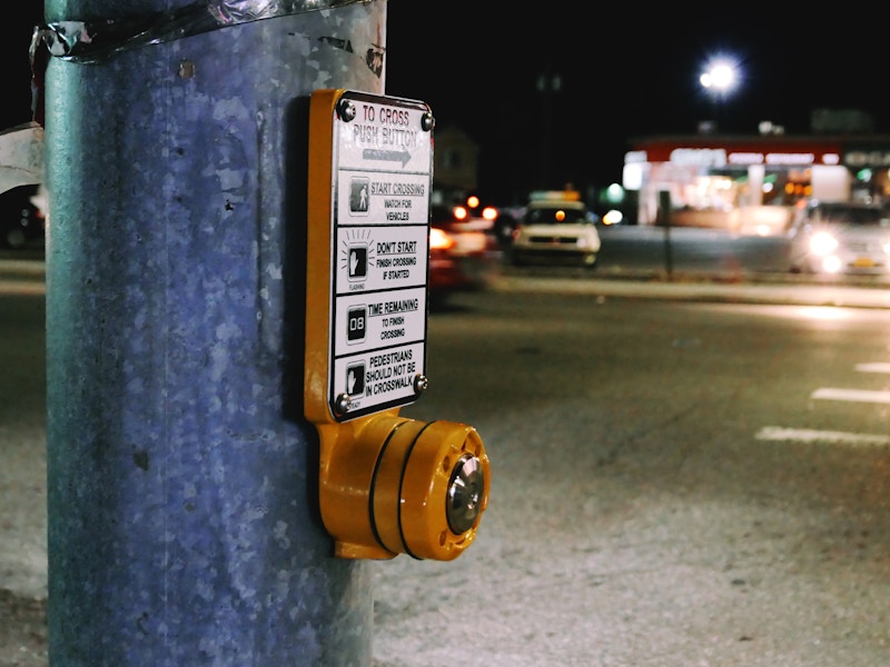 Photo: A close up of a pedestrian button in front of a street