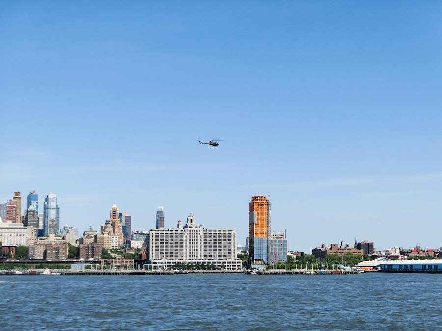 Photo: A helicopter flying over a city and a body of water 