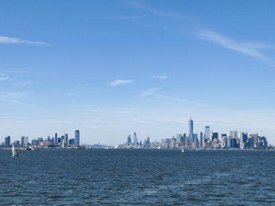 Manhattan Skyline - A body of water with a city skyline in the background under blue sky 