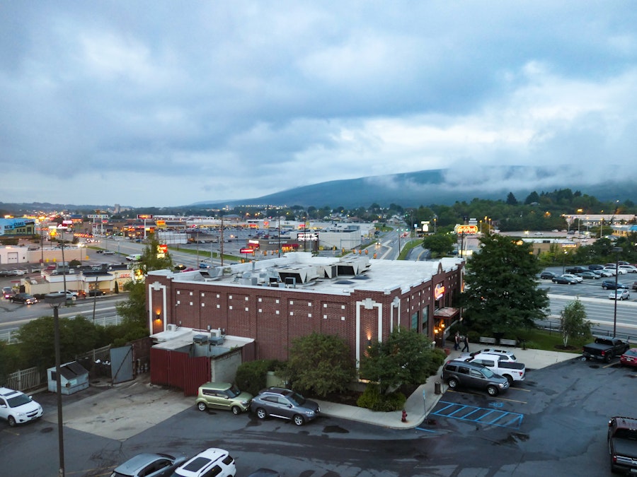 Photo: Buildings and Mountains Over Highway