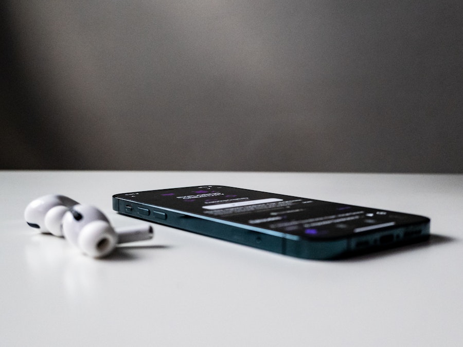 Photo: A smartphone and earbuds on a white table