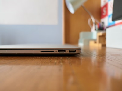 Laptop on Desk - A laptop in focus on a wooden desk with a blurred background 
