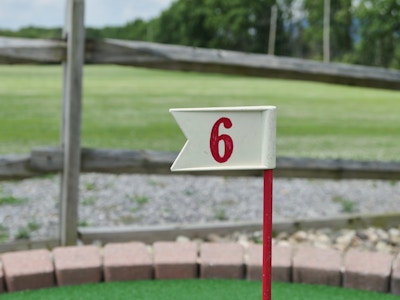 Mini Golf - A flag on a golf course with a red number 6