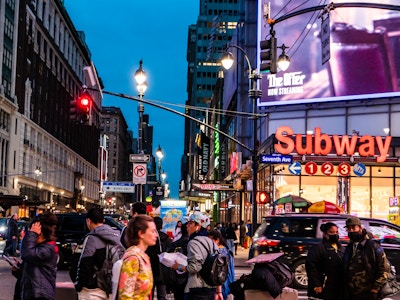 People Walking in Manhattan - A group of people walking on a busy street in a city