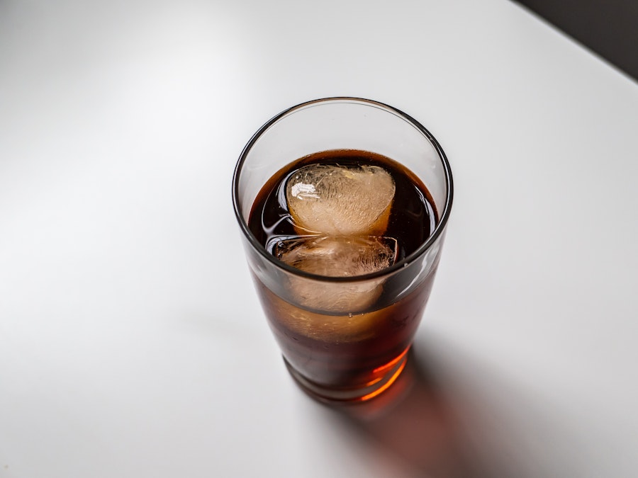 Photo: A glass of coffee with ice cubes on a white desk