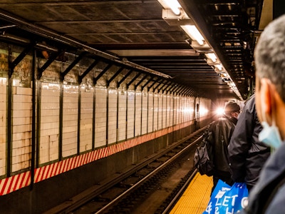 Train Approaching Subway Platform with People Waiting - People standing on a subway station platform 