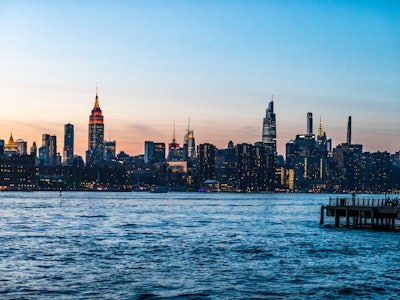 Manhattan Skyline in Sunset - A city skyline with a dock in the water during sunset 
