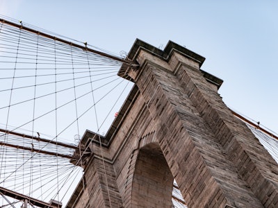 Brooklyn Bridge Under Sunset - Looking up at a bridge with ropes attached to it