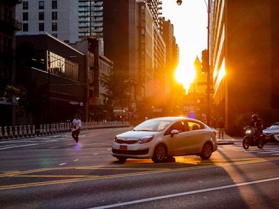 Sunset Over Brooklyn Street and Buildings - A car on the road with sunset and buildings behind it