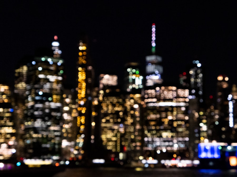 Photo: A blurry image of a city skyline at night