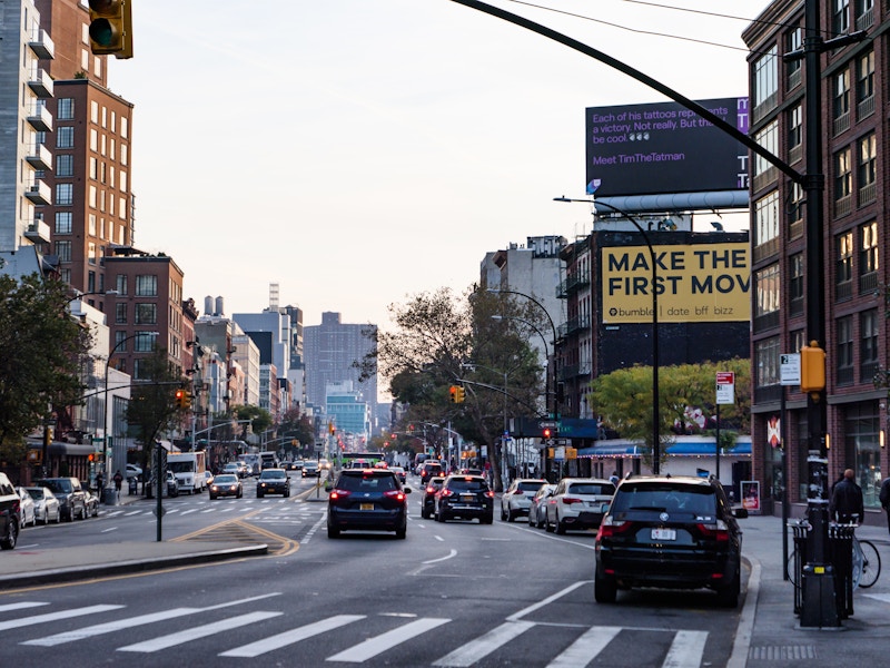 Photo: A street with cars, billboards, and buildings
