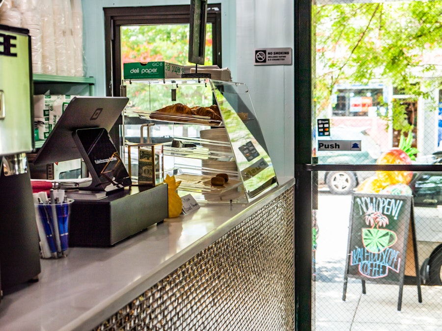 Photo: A counter in a coffee shop with a pastry display case