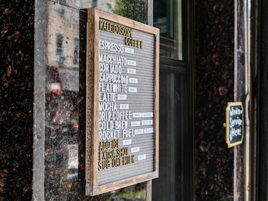 Photo: A gray menu board with white letters outside a coffee shop