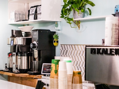 Coffee Machine and Cups at Coffee Shop - A coffee machine in a coffee shop with cups on the counter