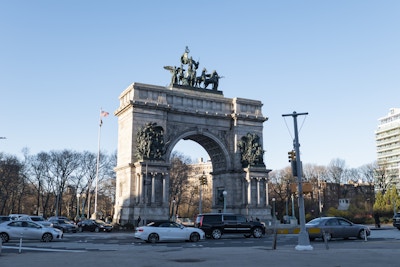 Grand Army Plaza - A large stone arch with statues on top in a city