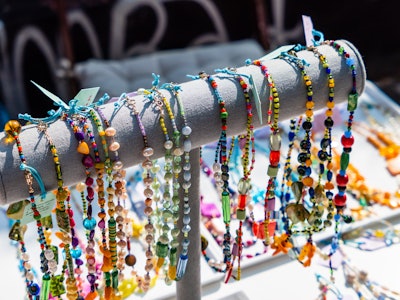 Handcrafted Jewelry at a Market - A group of colorful necklaces and beads on a rack
