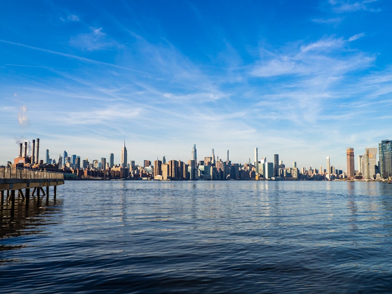 Photo: A full city skyline with a body of water under a blue sky