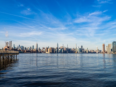 New York City Skyline and River - A full city skyline with a body of water under a blue sky