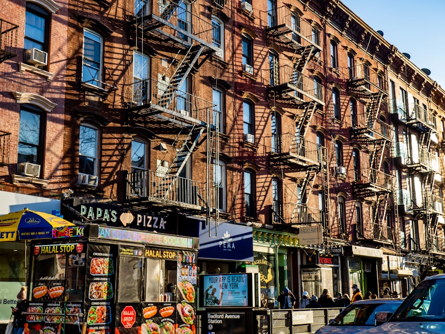 Photo: Many apartment buildings with fire escape stairs and businesses on ground level