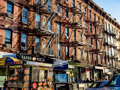Brooklyn Street with Shops, Subway, and and Buildings - Many apartment buildings with fire escape stairs and businesses on ground level