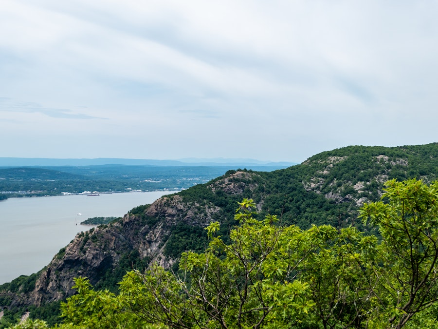 Photo: A mountain with trees and water in the background