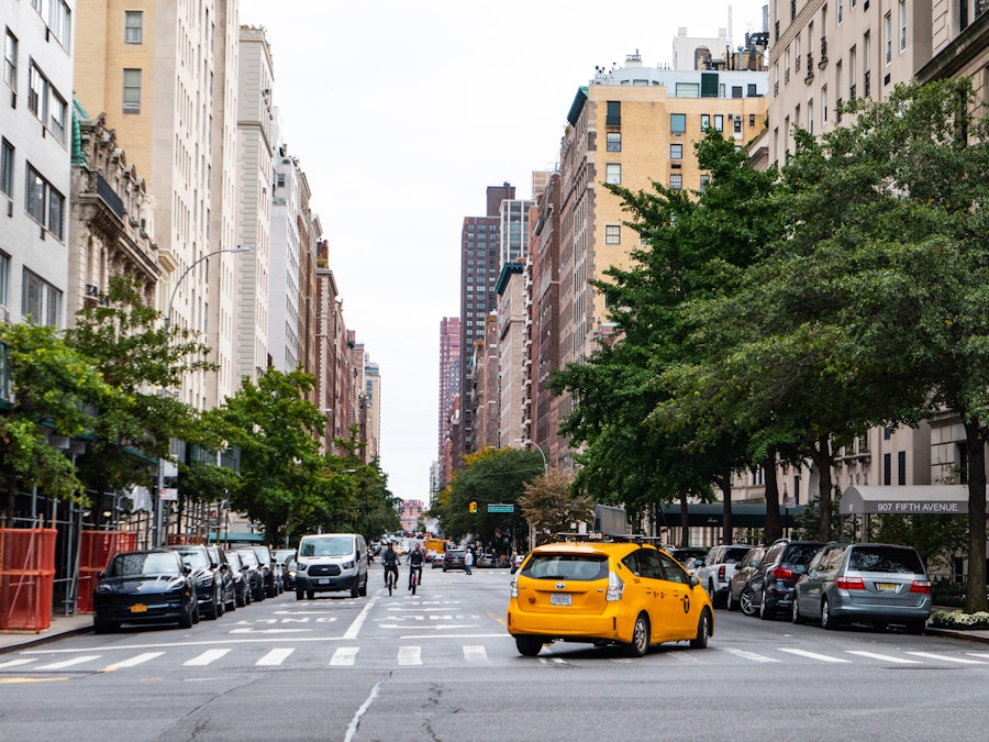 Photo: A yellow taxi on a street with many cars and buildings