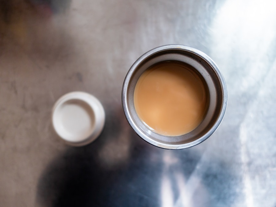 Photo: A metal cup of coffee with a lid