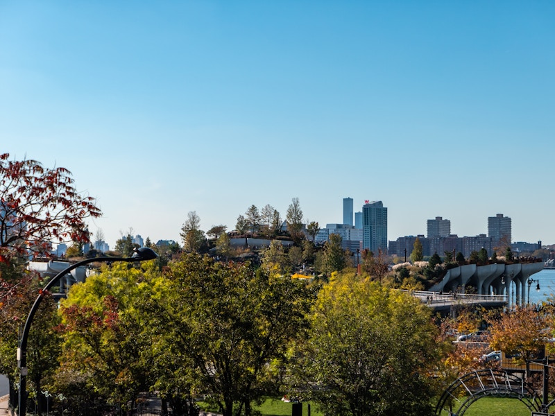 Photo: A city skyline with trees, parks, and a bridge