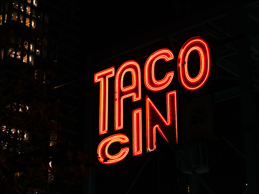 Photo: A neon sign with red letters at nighttime 