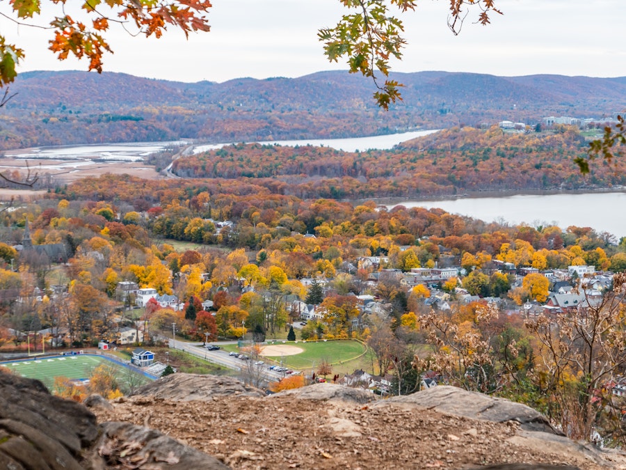 Photo: A landscape with trees, mountains, and a large river