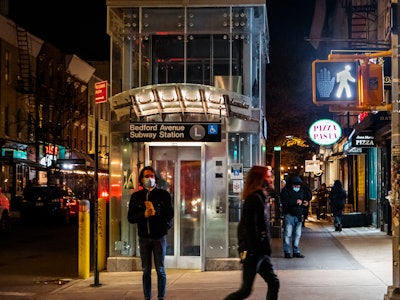 Brooklyn Street and Subway Station at Night - People walking on a city sidewalk with storefronts and a subway elevator 