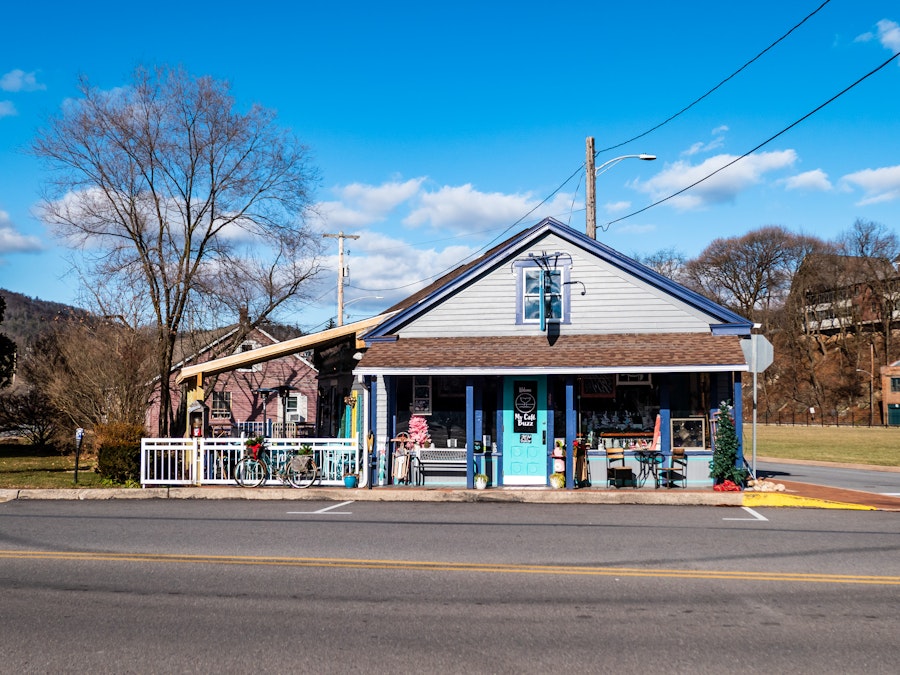 Photo: A small storefront with a white fence and outside sitting area