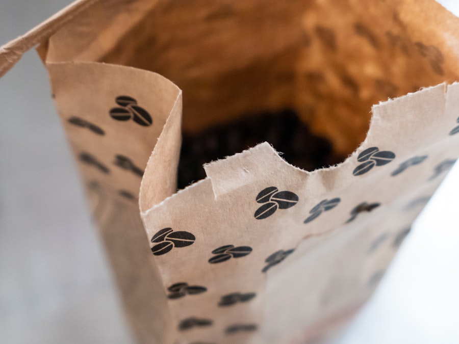 Photo: A brown bag with black coffee beans in it