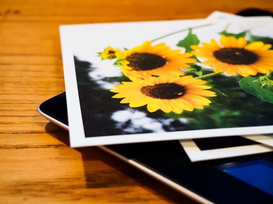 Photo: Tablet with Photo Prints on Desk