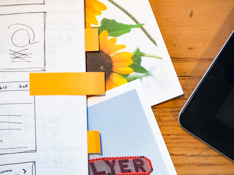 Photo: Wooden Desk with Sketchbook, Phone, and Photos