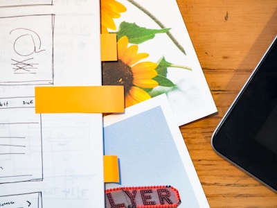 Wooden Desk with Sketchbook, Phone, and Photos