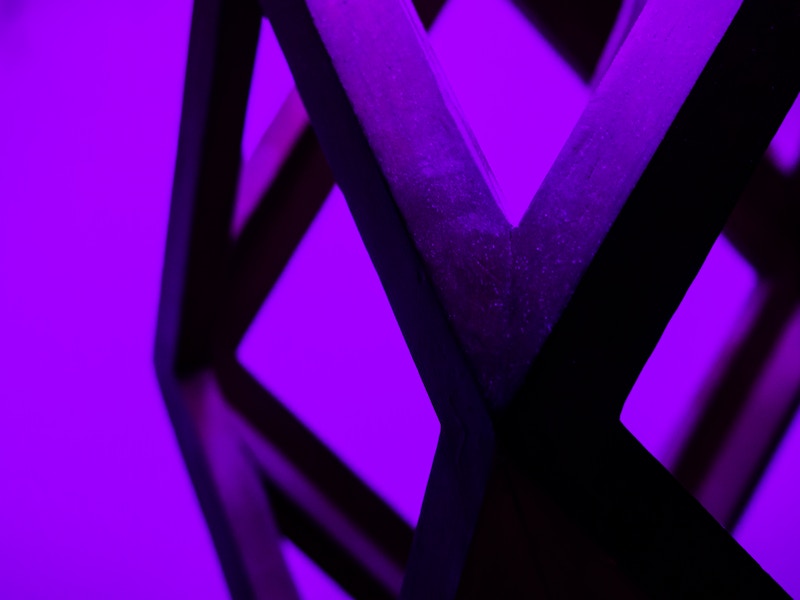 Photo: A close up of a lamp silhouetted on a purple wall