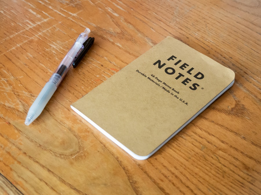 Photo: A notebook and pen on a wooden table