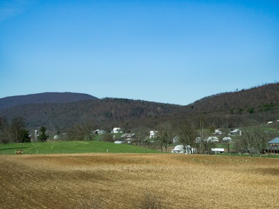 Field with Houses Over Blue Sky