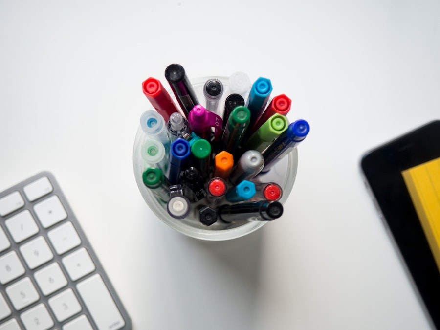 Photo: White Desk with Keyboard, Pens, and Phone