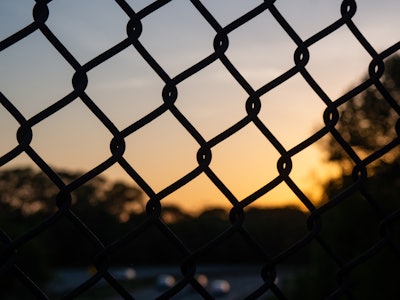 Sunset - A close up of a silhouetted fence during sunset 