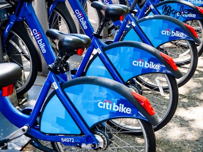 Row of Bicycles - A group of blue bicycles parked on the sidewalk