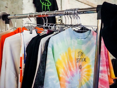 Shirts on Hangers at Flea Market - A metal clothing rack with different colored shirts at a market 