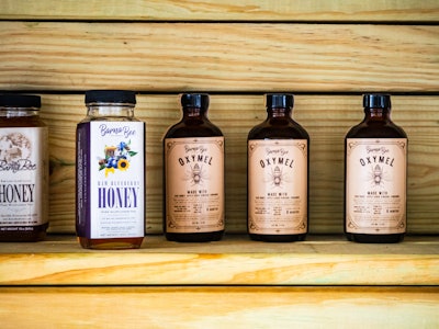 Jars of Honey on Wood Shelf at a Market - A group of honey bottles on a shelf